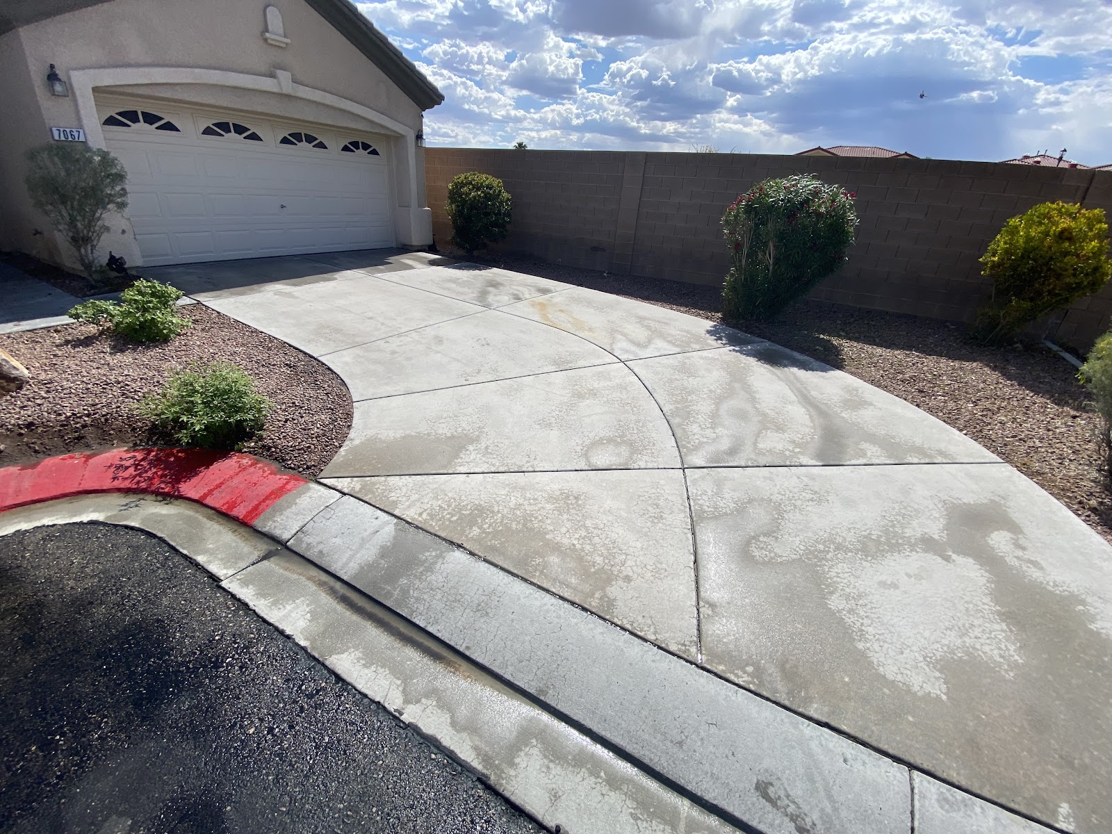 Residential concrete driveway partially cleaned, showing a sharp before and after contrast